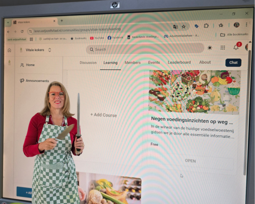 beeldscherm met videocursus op voorgron coach dinie met aanzetstaal en mes